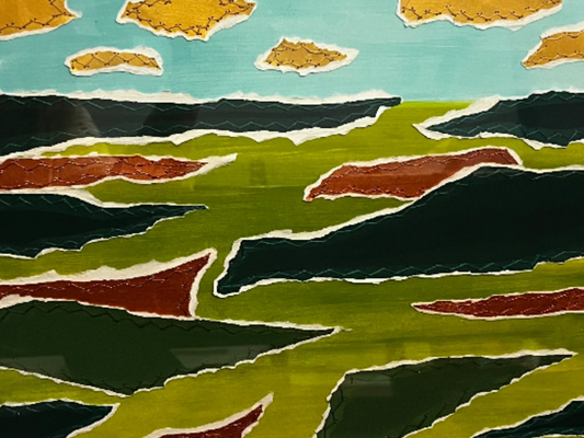 Framed artwork of a landscape with green fields and blue sky.